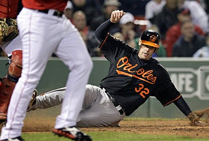 Baltimore's Matt Wieters slides at home plate to score a run in the 13th off a single by Chris Davis. (AP)