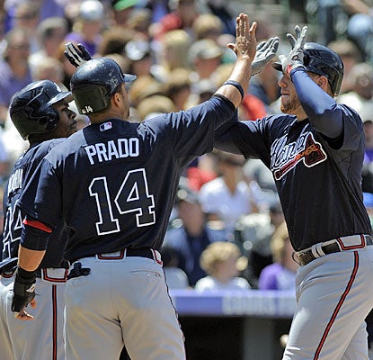 Freddie Freeman (right) has a greeting party after hitting a three-run homer to help the Braves to a sweep in Colorado.  (AP)