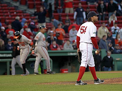 Boston outfielder-turned-reliever Darnell McDonald gathers himself after allowing the deciding HR to Adam Jones (left).  (US Presswire)