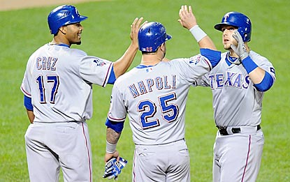 Veterans Nelson Cruz and Mike Napoli greet rookie Brandon Snyder after they score on his three-run blast in the sixth.  (Getty Images)