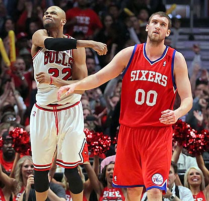 Taj Gibson celebrates while Sixers center Spencer Hawes laments a missed opportunity to knock out the injury-plagued Bulls.  (US Presswire)