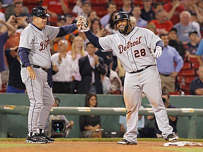 Prince Fielder shares a laugh with third-base coach Gene Lamont after hitting a triple in the ninth inning. He later scores.  (Getty Images)