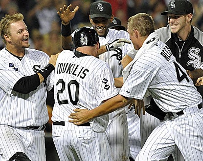 Kevin Youkilis is mobbed by his teammates after hitting the game-winning RBI-single in the 10th inning. (AP)
