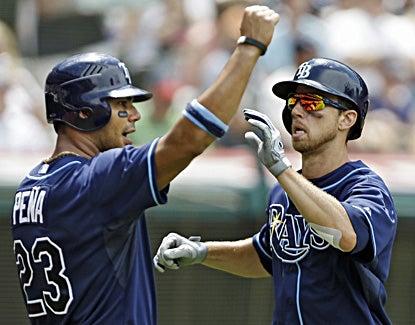 Carlos Pena (left) and Ben Zobrist celebrate after scoring on Luke Scott's double in the sixth inning. (AP)