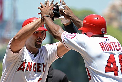 Albert Pujols is greeted by teammate Torii Hunter after connecting for a two-run homer against the Orioles.  (Getty Images)