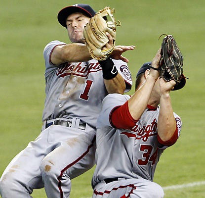 Bryce Harper (right) finishes off the Marlins by catching the final out, but not before colliding with 2B Steve Lombardozzi. (AP)