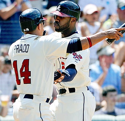 Jason Heyward (right) celebrates with Martin Prado after hitting a solo home run off of Roy Halladay in the first inning. (AP)