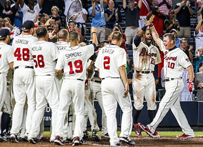 The Braves wait at home plate for Chipper Jones, who delivers a game-ending three-run shot in the ninth. (AP)