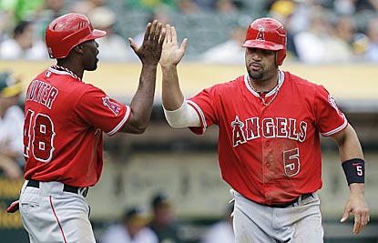 Torii Hunter and Albert Pujols celebrate after scoring on Howie Kendrick's single in the third inning.  (AP)