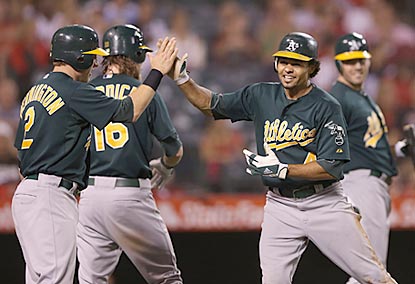 Coco Crisp celebrates with Oakland teammates after scoring on an error during the ninth inning.  (Getty Images)