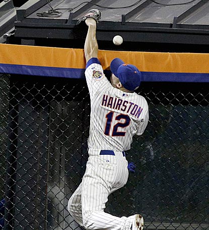 Scott Hairston leaps for Jimmy Rollins' deep fly, which hits the bullpen roof beyond the fence for a home run in the fifth.  (AP)