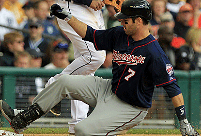 Joe Mauer, who tallies three hits and four RBI, slides safely into third base as the Twins oust the Tigers.  (AP)