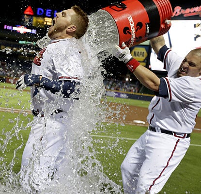 Freddie Freeman, who receives a little hero treatment, helps the Braves clinch the second-to-last playoff spot left in the NL. (AP)