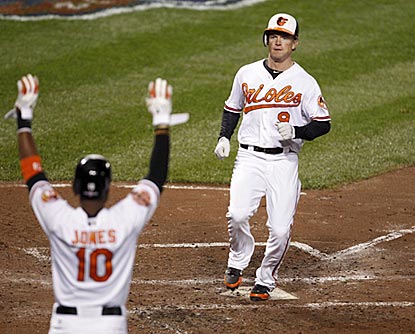 Adam Jones welcomes home Nate McLouth, who scores off a Chris Davis hit in the third inning. (US Presswire)
