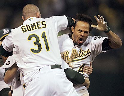 A's outfielder Johnny Gomes is among the first to grab Coco Crisp after his single pushes this AL division series to the limit. (AP)
