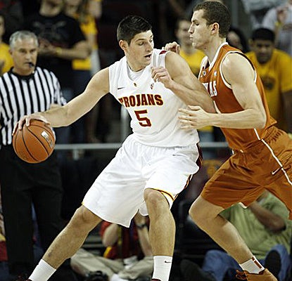 USC's Nikola Vucevic, left, is defended by Texas' Matt Hill on his way to scoring 24 points in the Trojans' upset win. (AP)