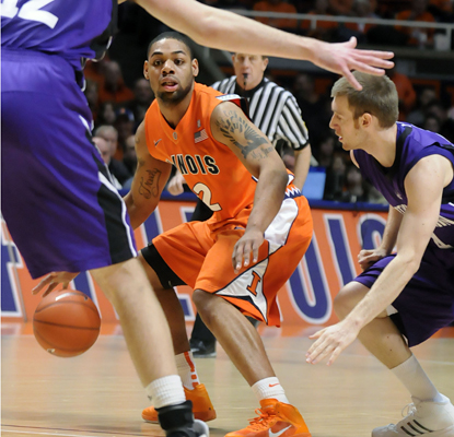 Illinois' Demtri McCamey looks for an opening between Northwestern defenders as he works his way to scoring 14 points. (AP)