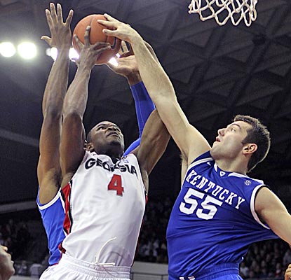 Chris Barnes pulls down a rebound between two Wildcats to help the Bulldogs to their ninth straight win. (AP)