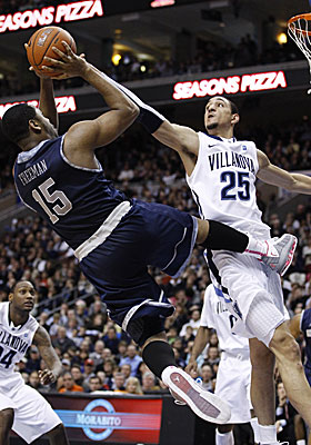 Georgetown's Austin Freeman gets a shot off over Villanova's Maurice Sutton. (AP)