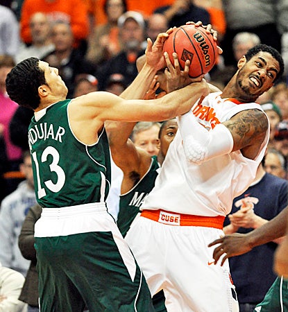 Syracuse's Fab Melo (right) fights for the ball, earning 11 points and a career-high nine rebounds against Manhattan. (AP)