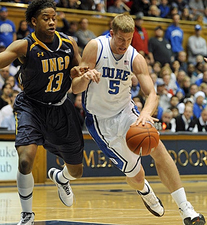 UNCG's Aloysius Henry (left) pressures Mason Plumlee, who scores 15 points and grabs 13 rebounds in Duke's 90-63 win. (AP)