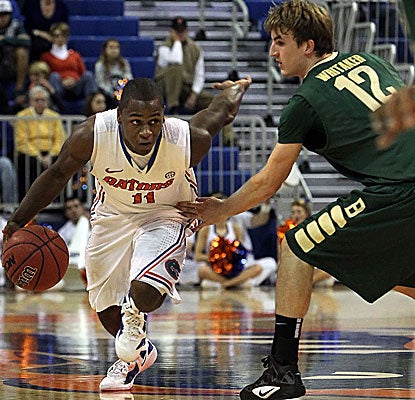 The Gators' Erving Walker (left) drives to the hoop for two of his game-high 23 points. (US Presswire)