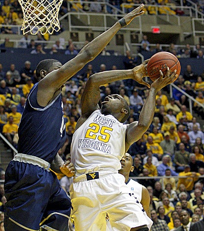 Georgetown's Henry Sims (left) fouls West Virginia's Darryl Bryant, who scores a game-high 25 points in the Mountaineers' win. (AP)