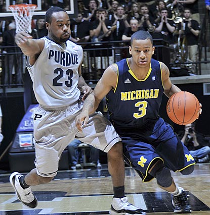 Trey Burke, shown dribbling against Purdue's Lewis Jackson, helps Michigan escape Mackey Arena with a victory.  (US Presswire)
