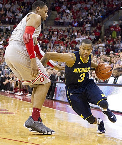 Michigan guard Trey Burke looks for driving room around Ohio State's Jared Sullinger, his former high school teammate.  (US Presswire)
