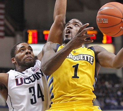 UConn big man Alex Oriakhi tries to deny Marquette's Darius Johnson-Odom, who finishes with 24 points.  (US Presswire)
