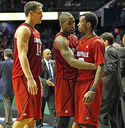 Louisville's Kyle Kuric (left) and Chris Smith celebrate with Russ Smith (right), who hits bacck-to-back baskets in overtime. (AP)