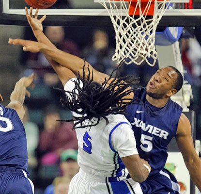 Jordair Jett draws the foul, but Dezmine Wells has the last word, scoring 18 points in Xavier's victory.  (US Presswire)