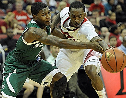 Louisville guard Russ Smith steals the ball from Manhattan's CJ Jones. Smith scores 23 points for the Cardinals. (US Presswire)