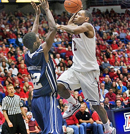 Mark Lyons (right), who scores 17 points to lead the Wildcats, drives the lane against Oral Roberts' Steven Roundtree. (AP)