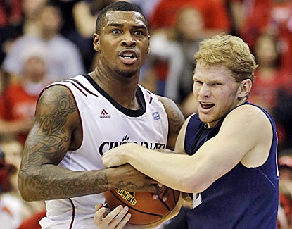 Sean Kilpatrick (left) ties up Xavier's Brad Redford during Cincinnati's win. Kilpatrick scores a game-high 25 points. (AP)