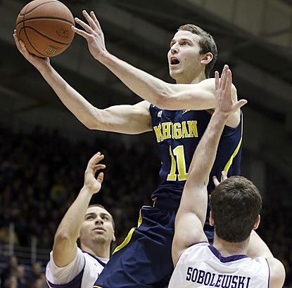 Michigan guard Nik Stauskas drives to the basket between Northwestern guards Tre Demps (left) and Dave Sobolewski.  (AP)