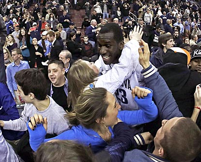 Villanova's Daniel Ochefu is mobbed by fans after the Wildcats upend the Cardinals for a much-needed victory.  (AP)