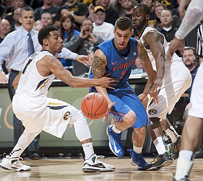 Florida's Scottie Wilbekin loses control of the ball as he drives between Missouri's Phil Pressey (left) and Keion Bell.  (AP)