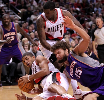 The Trail Blazers' Nicolas Batum (left) battles the Suns' Robin Lopez for possession in the season opener. (AP)