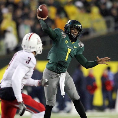 The Ducks QB Darron Thomas passes for 148 yards and three TDs -- he rushes for one more.  (AP)