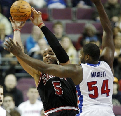Carlos Boozer passes the ball against Jason Maxiell and ends up leading the Bulls with 31 points to go with 11 rebounds. (AP)