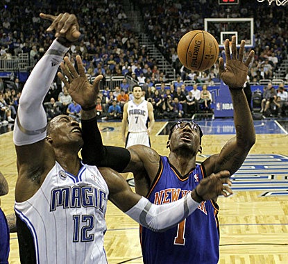 Magic center Dwight Howard takes an elbow to the chops while battling Amar'e Stoudemire for a rebound. (AP)