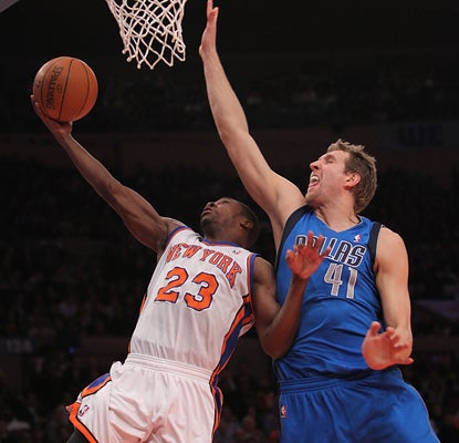 Dirk Nowitzki, right, plays defense on Toney Douglas and contributes 29 points and 11 rebounds. (Getty Images)