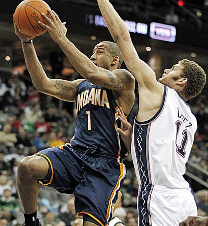 Dahntay Jones (left) goes up for two of his game-high 18 points against New Jersey's Brook Lopez. (AP)