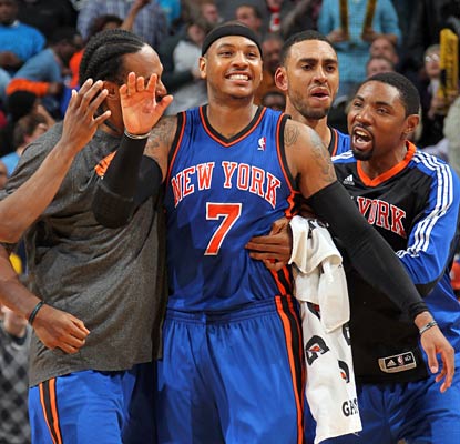 Carmelo Anthony is mobbed by his new teammates after he nails the winning jumper with 0.5 seconds left. (Getty Images)