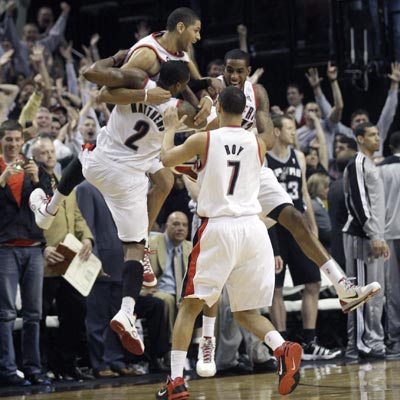Nicolas Batum celebrates with teammates after draining the game winner against Tony Parker and the Spurs.   (AP)