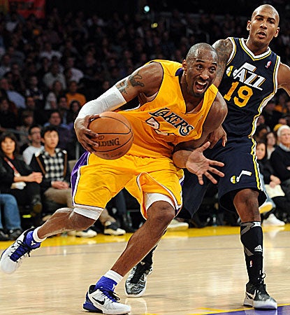 Battling a painful wrist injury, Los Angeles' Kobe Bryant blows by Utah's Raja Bell for two for his game-high 26 points.  (Getty Images)