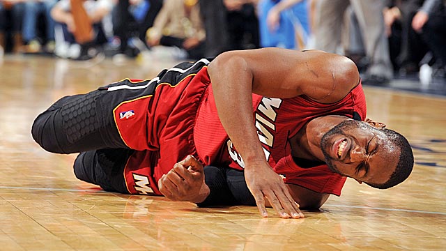Wade grimaces in pain after injuring his ankle against the Nuggets on Friday. (Getty Images)