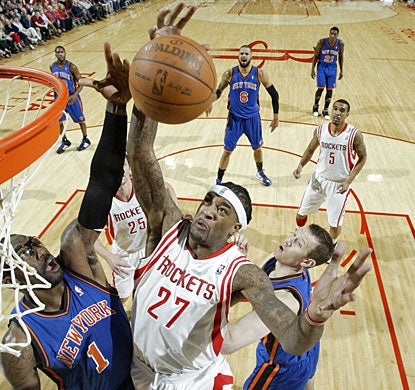 Jordan Hill pulls down one of his 11 rebounds over Amare Stoudemire. Hill also scores 14 as Houston improves to 9-2 at home. (Getty Images)