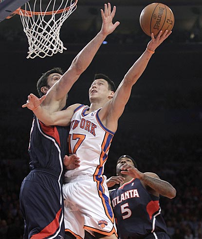 Jeremy Lin attacks the basket and uses his left hand to score a layup against Atlanta's Zaza Pachulia in the opening minutes.  (AP)